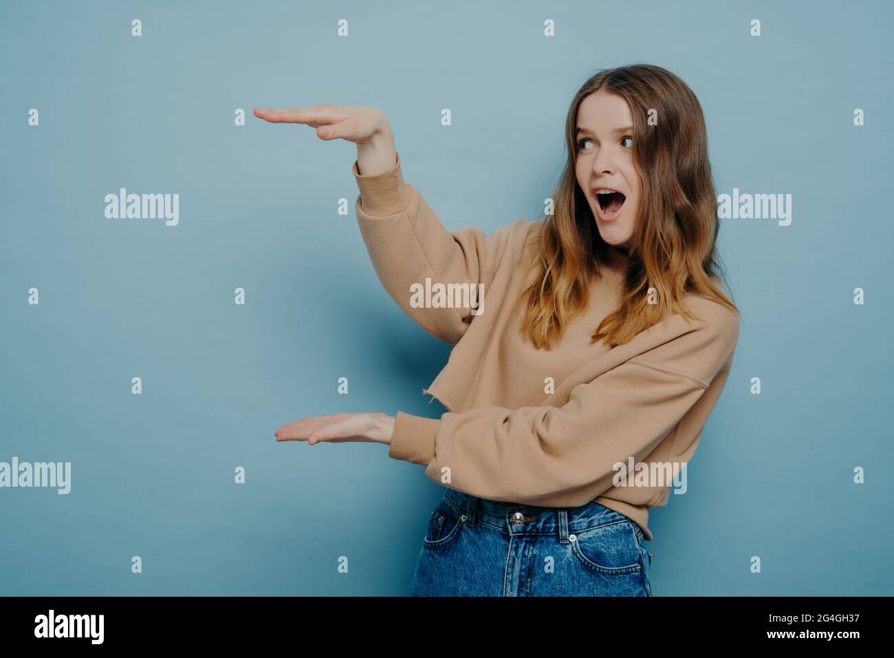 Young teen girl showing size with hands Stock Photo