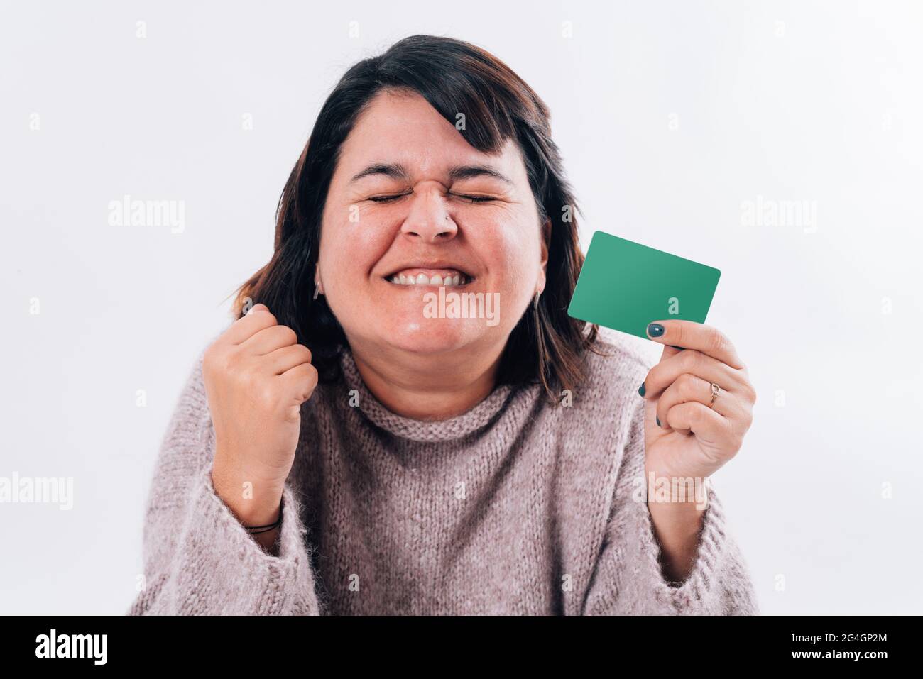 Exaggeratedly happy woman who squeezes her eyes with an online shopping ...
