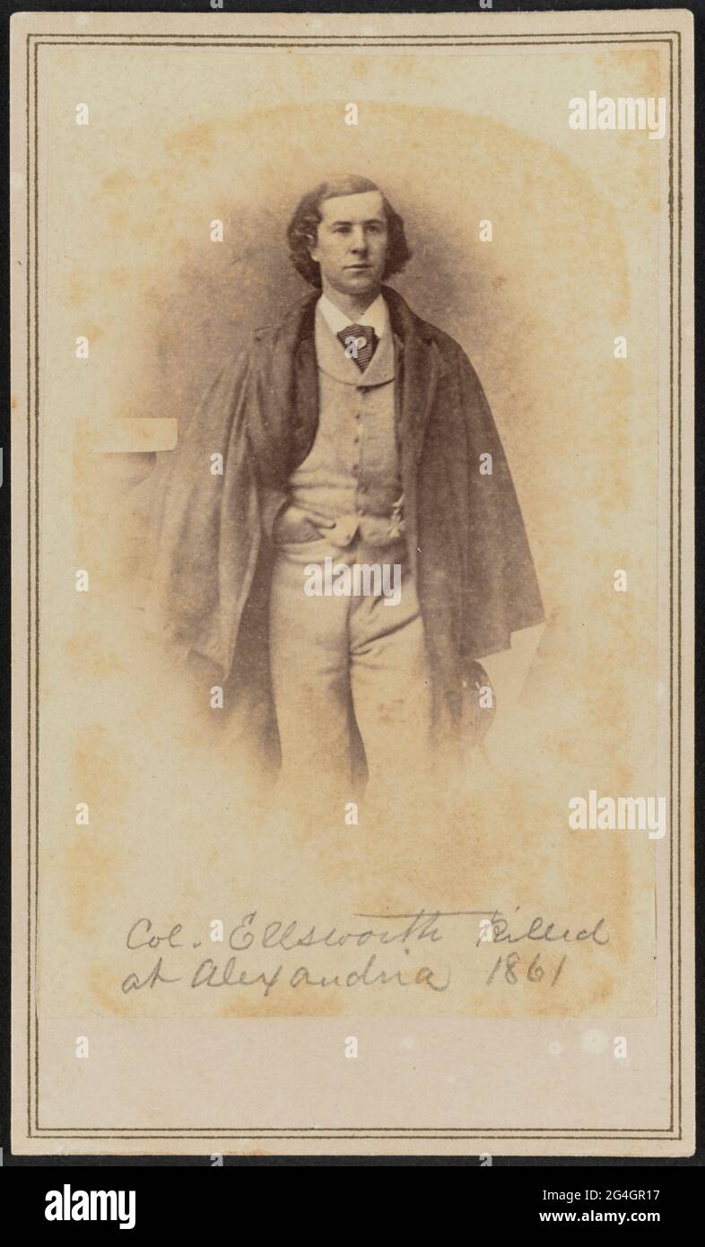 Carte-de-visite of Col. Elmer Ephraim Ellsworth shown in three-quarter portrait. Ellsworth stands facing the camera with his right hand in his trouser pocket. He wears a light colored vest and trousers, a dark jacket, a dark cloak, a white shirt, and a dark necktie with a tie pin. The bottom portion of the image is purposefully faded in the popular style of the time. There is a double-lined border printed in gold ink surrounding the outside edges of the card mount.;Handwritten in graphite on the bottom of the print is the text &quot;Col. Ellsworth killed / at Alexandria 1861&quot;. There is a Stock Photo