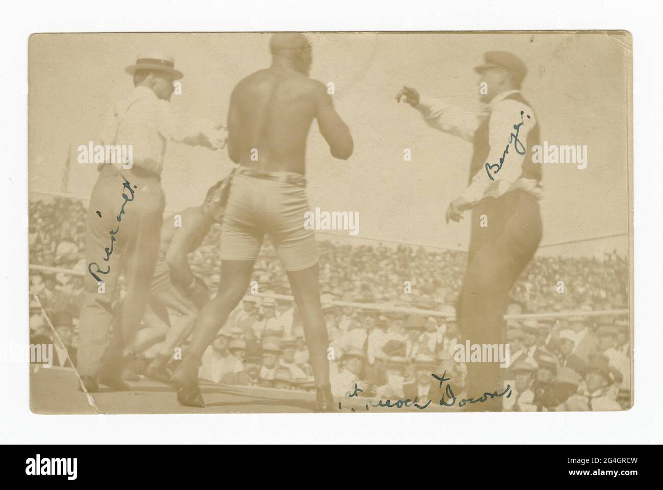 &quot;Fight of the Century&quot; between Jack Johnson and James J. Jeffries in Reno, Nevada. Jeffries can be seen in the background to be staggering away from Johnson. Two officials also stand in the ring. Their names are written in ink on their images. There postcard has been mailed and there is writing and a green one cent stamp on the reverse of the postcard. Jeffries is perhaps most famous for being United States &quot;Great White Hope&quot;, since the nation expected him to come out of his retirement to beat the African-American boxer Jack Johnson. Johnson, the first Black American world Stock Photo