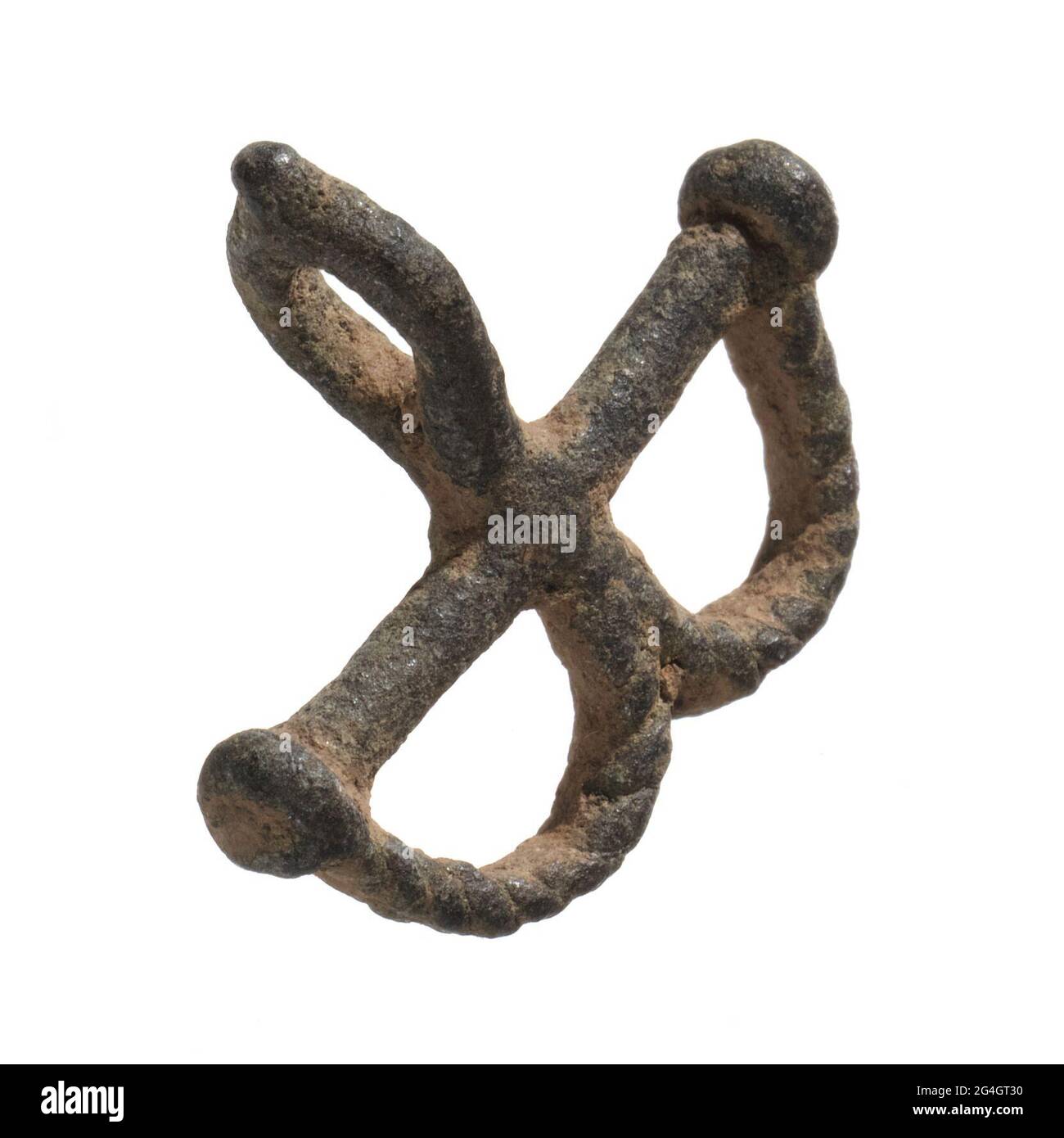 A miniature pair of shackles used as a protective amulet by the Lobi tribe of West Africa in what is now Ghana. The bronze shackles consist of a pair of loops linked to a single bolt. There is a third loop at the top of the amulet. The bronze is covered with a dark patina. Stock Photo