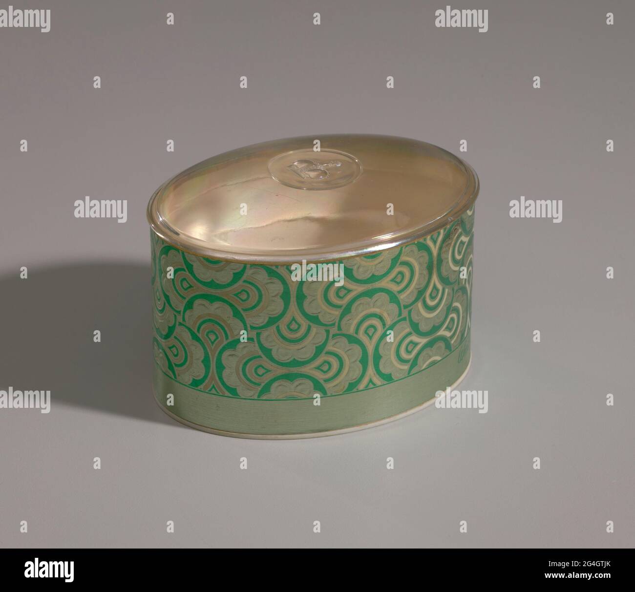 https://c8.alamy.com/comp/2G4GTJK/an-empty-makeup-box-for-loose-powder-the-ovular-container-a-is-covered-on-the-exterior-sides-with-green-and-gold-foil-in-a-stylized-floral-design-it-reads-quotwind-song-perfumed-dusting-powderquot-in-green-along-the-bottom-edge-of-one-short-side-the-bottom-of-the-container-is-made-from-hard-white-plastic-with-molded-lettering-on-the-bottom-that-reads-quotprince-matchabelli-inc-dist-perfumed-dusting-powder-net-wt-5-oz-greenwich-conn-06830quot-the-interior-of-the-container-is-lined-with-pasteboard-the-lid-b-is-made-from-clear-plastic-and-is-slightly-convex-with-a-mo-2G4GTJK.jpg