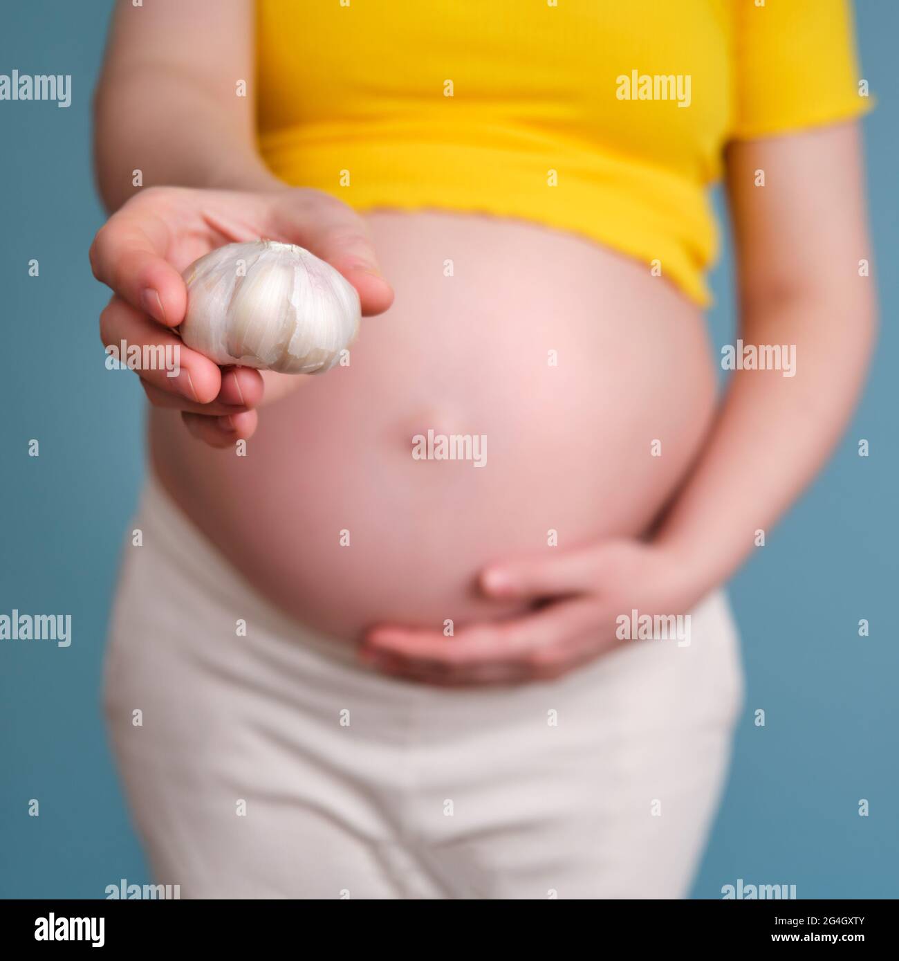 Spices in the hand of a pregnant woman. Garlic during pregnancy Stock