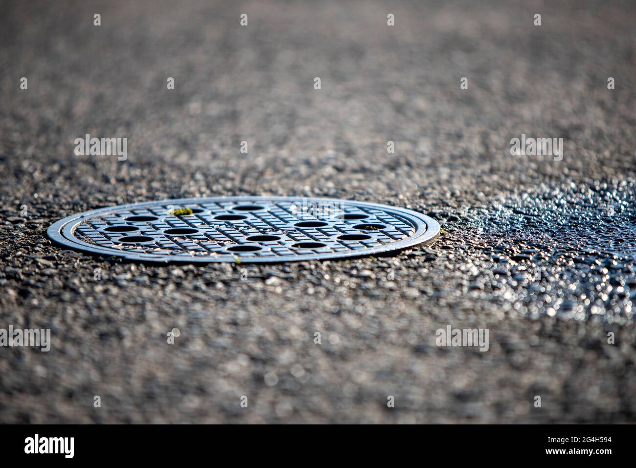 closeup of a manhole cover in asphalt Stock Photo