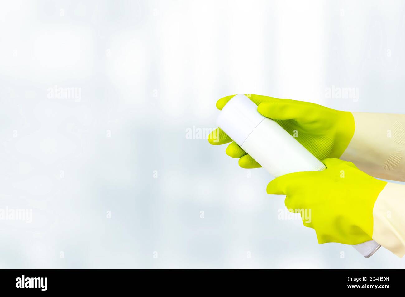Spring cleaning concept. Top view of hand in yellow rubber gloves holding Sprayed air freshener. Cleaning concept, cleaning service Stock Photo