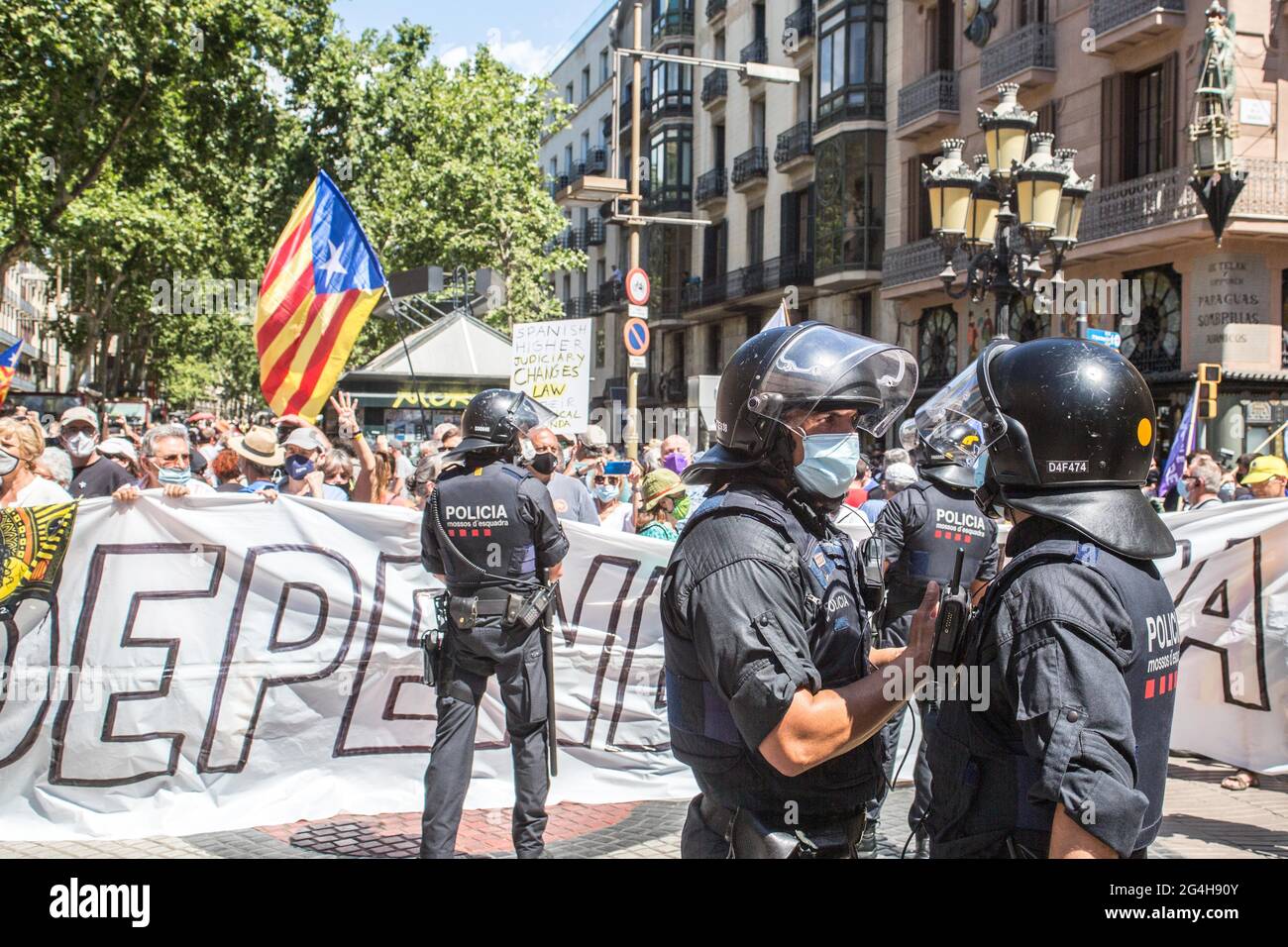 Police seen in front of protesters with Catalan independence flags and a banner saying 'Independence' during the demonstration.Hundreds of Catalan independentistas have demonstrated in Las Ramblas in Barcelona, in front of the Gran Teatre del Liceu (Great Theater of the Lyceum), shielded by many policemen, to protest the visit of the President of the Spanish Government, Pedro Sanchez, who has held a conference entitled 'Reunion: a project for the future for all of Spain', with the expectation of an imminent granting of pardons for the independence leaders in prison. The protesters protested to Stock Photo
