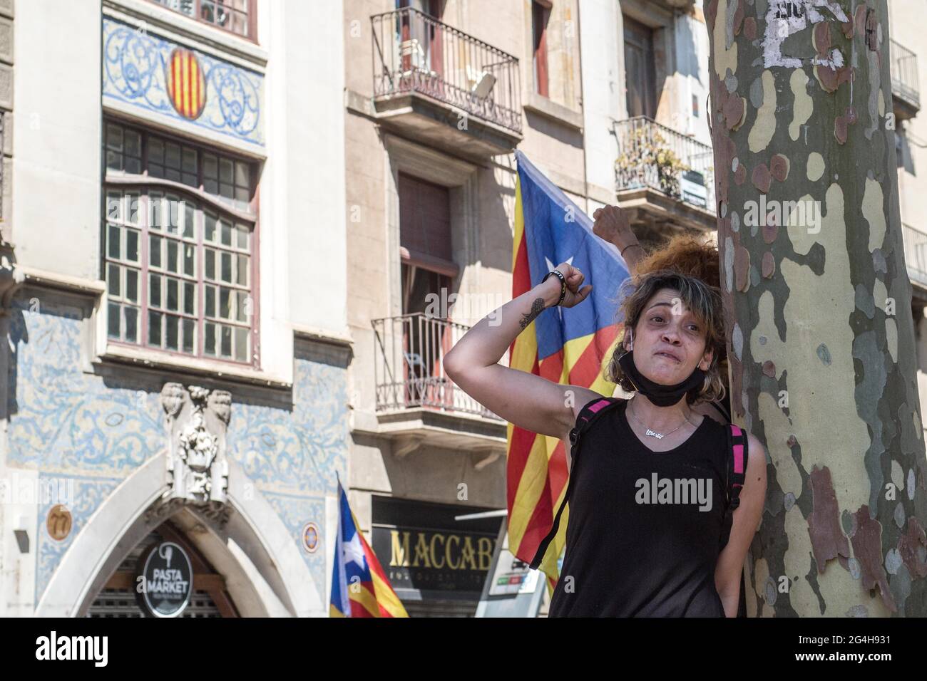A protester chants slogans in front of Catalan independence flag during the demonstration.Hundreds of Catalan independentistas have demonstrated in Las Ramblas in Barcelona, in front of the Gran Teatre del Liceu (Great Theater of the Lyceum), shielded by many policemen, to protest the visit of the President of the Spanish Government, Pedro Sanchez, who has held a conference entitled 'Reunion: a project for the future for all of Spain', with the expectation of an imminent granting of pardons for the independence leaders in prison. The protesters protested to denounce that the repression against Stock Photo