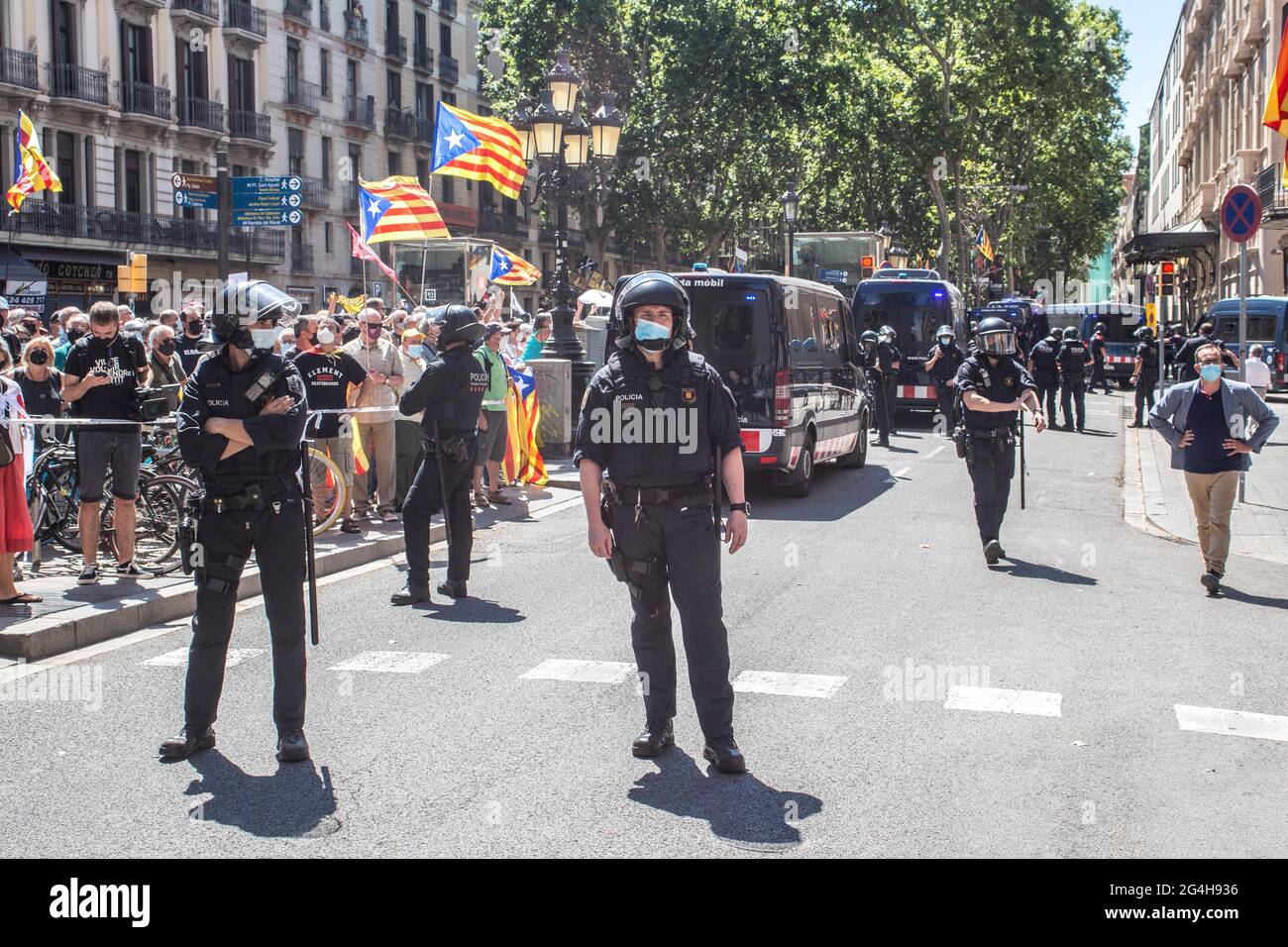 Protesters are seen with Catalan independence flags behind the police during the demonstration.Hundreds of Catalan independentistas have demonstrated in Las Ramblas in Barcelona, in front of the Gran Teatre del Liceu (Great Theater of the Lyceum), shielded by many policemen, to protest the visit of the President of the Spanish Government, Pedro Sanchez, who has held a conference entitled 'Reunion: a project for the future for all of Spain', with the expectation of an imminent granting of pardons for the independence leaders in prison. The protesters protested to denounce that the repression ag Stock Photo
