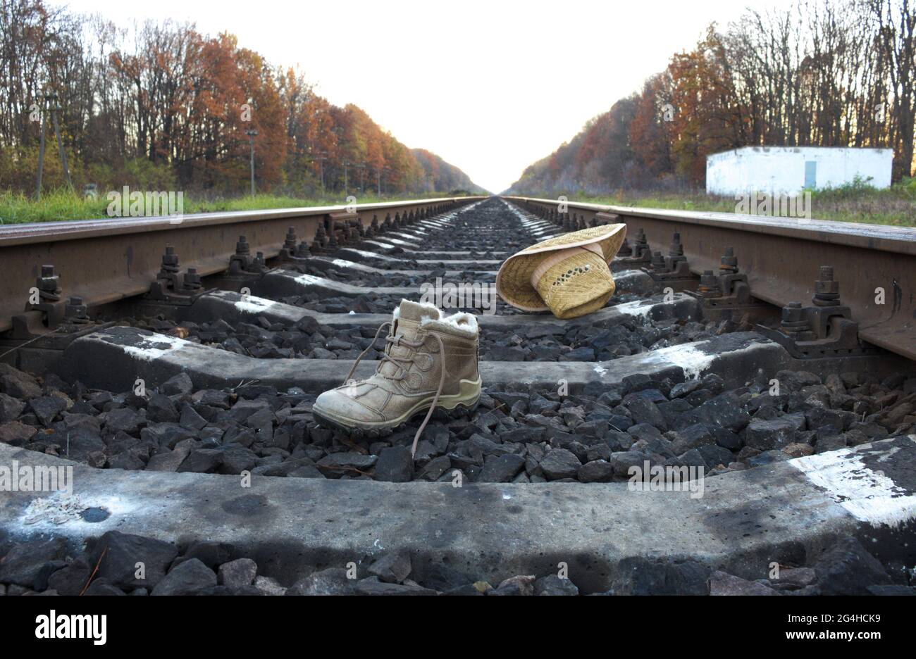 On railroad tracks lie shoes and hat. Stock Photo