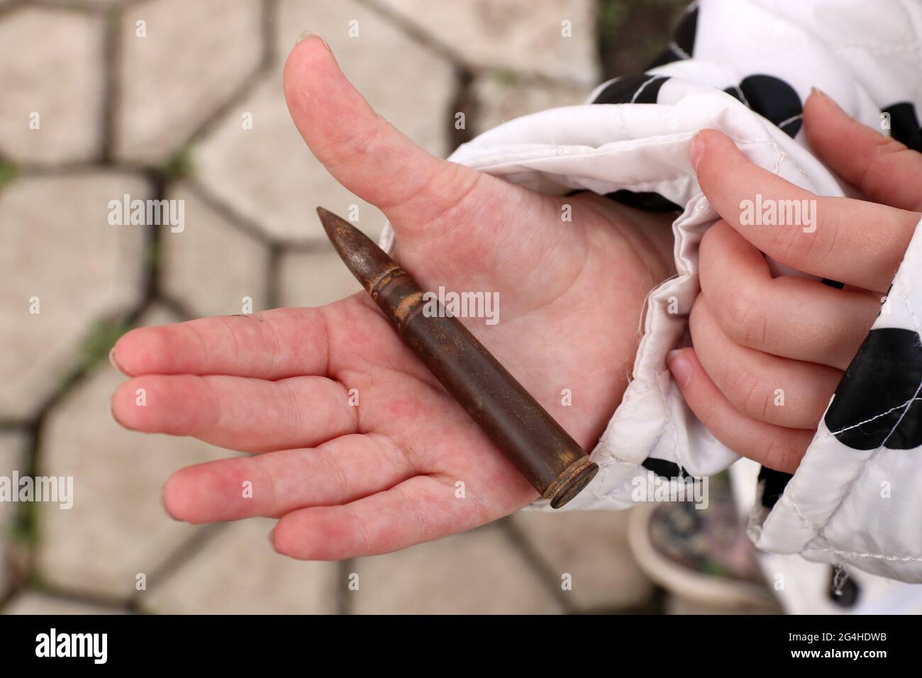 The child is holding bullet for the  assault rifle. Selective focus. Stock Photo