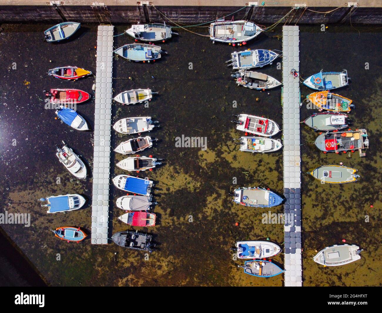 Aerial view from drone of fishing boats in harbour at historic village of Gardenstown on Moray firth Coast in Aberdeenshire, Scotland, Uk Stock Photo