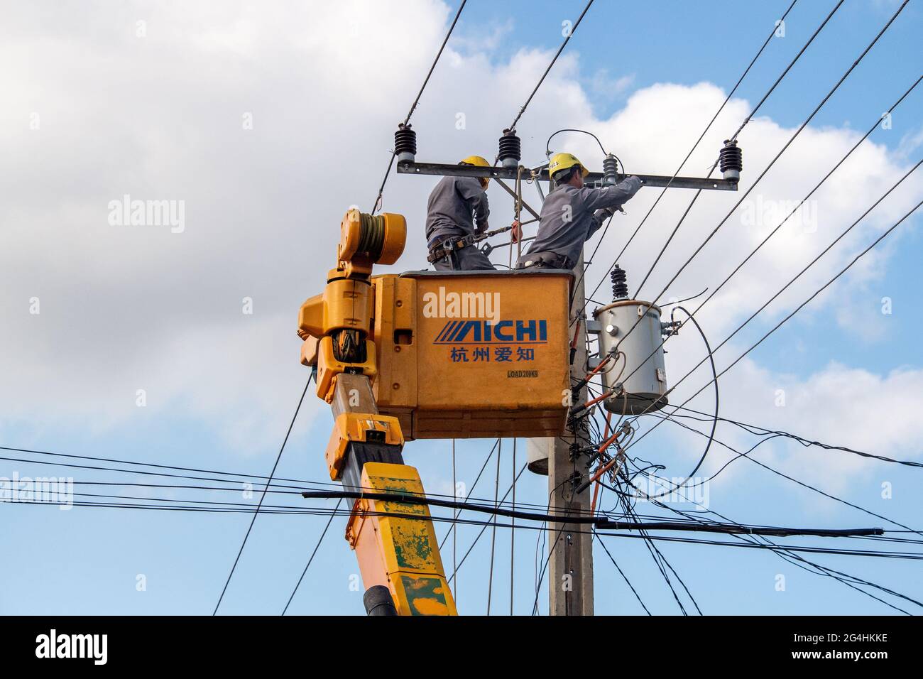 Hot-wire electricians working in a bucket truck in Cuba Stock Photo