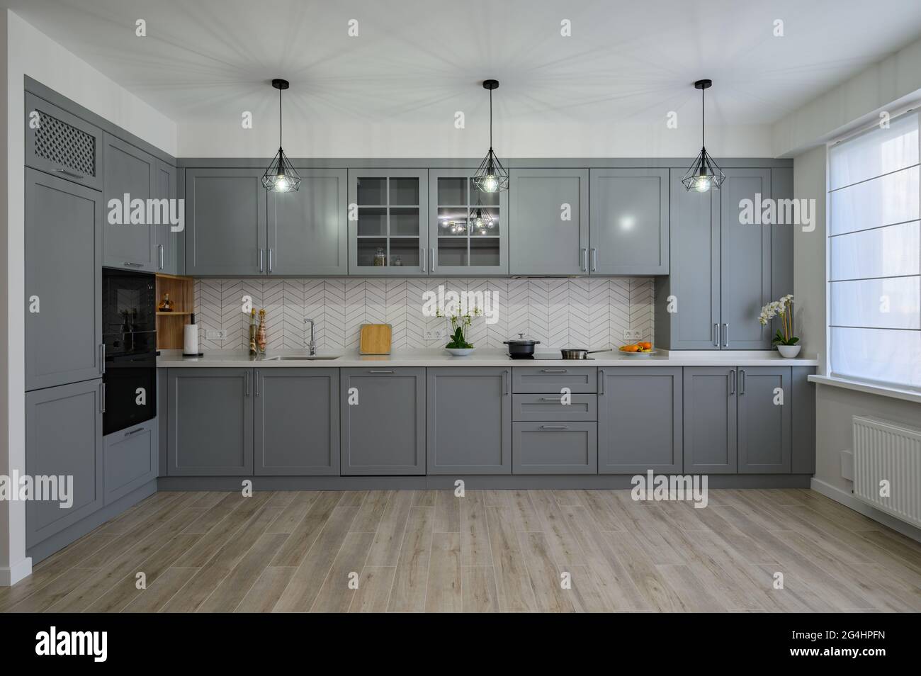Trendy grey and white modern kitchen furniture, front view Stock Photo