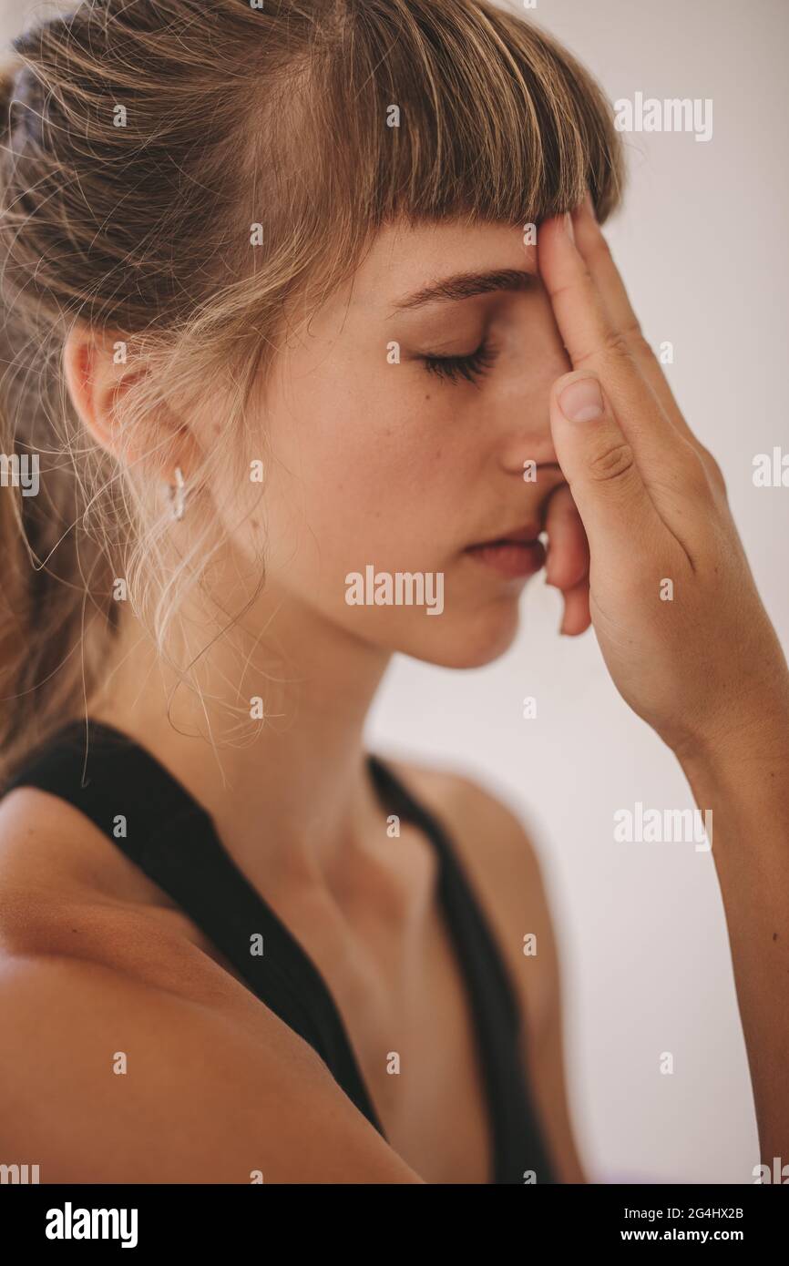 Close up of woman practicing yoga exercise. Alternate nostril breathing technique performed in yoga class. Stock Photo