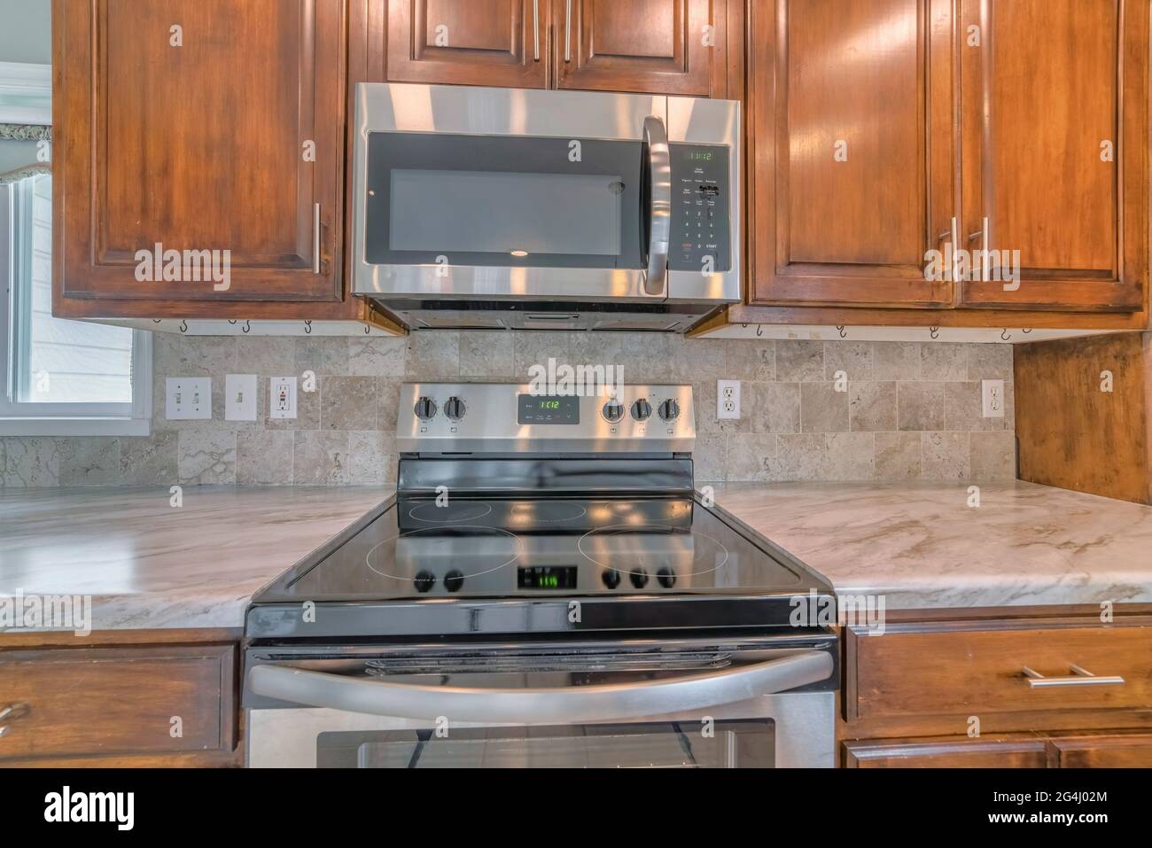 A tiled wall kitchen setup with wooden shelves, cooking equipment Stock