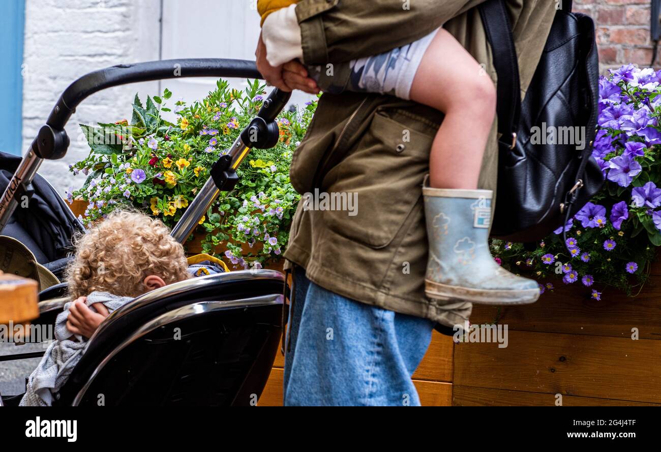 Mother with and push chair holding child, Fowey, Cornwall Stock Photo