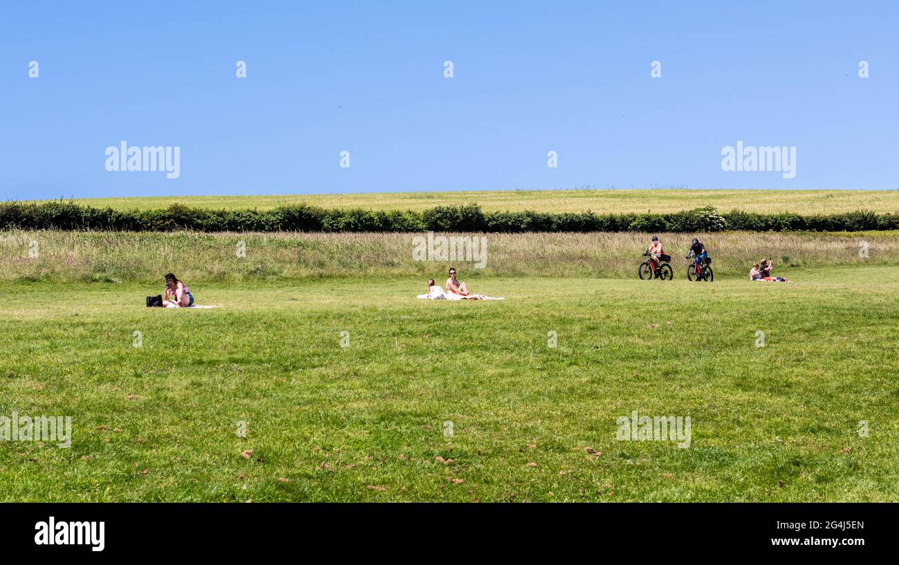 People on holiday picnicking and cycling, Padstow, Cornwall Stock Photo
