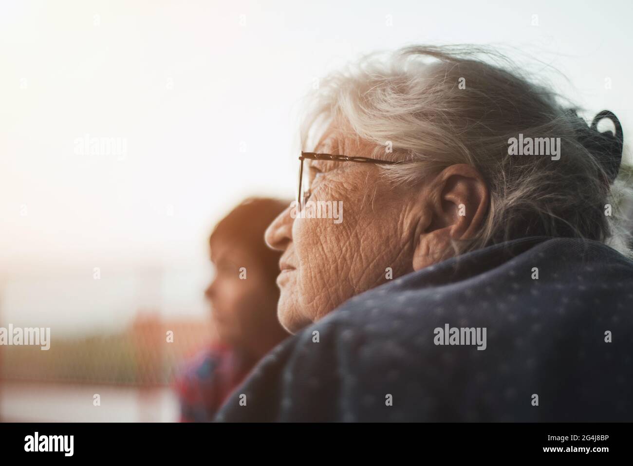 Two mature women, one blurred in background, looking at sky Stock Photo