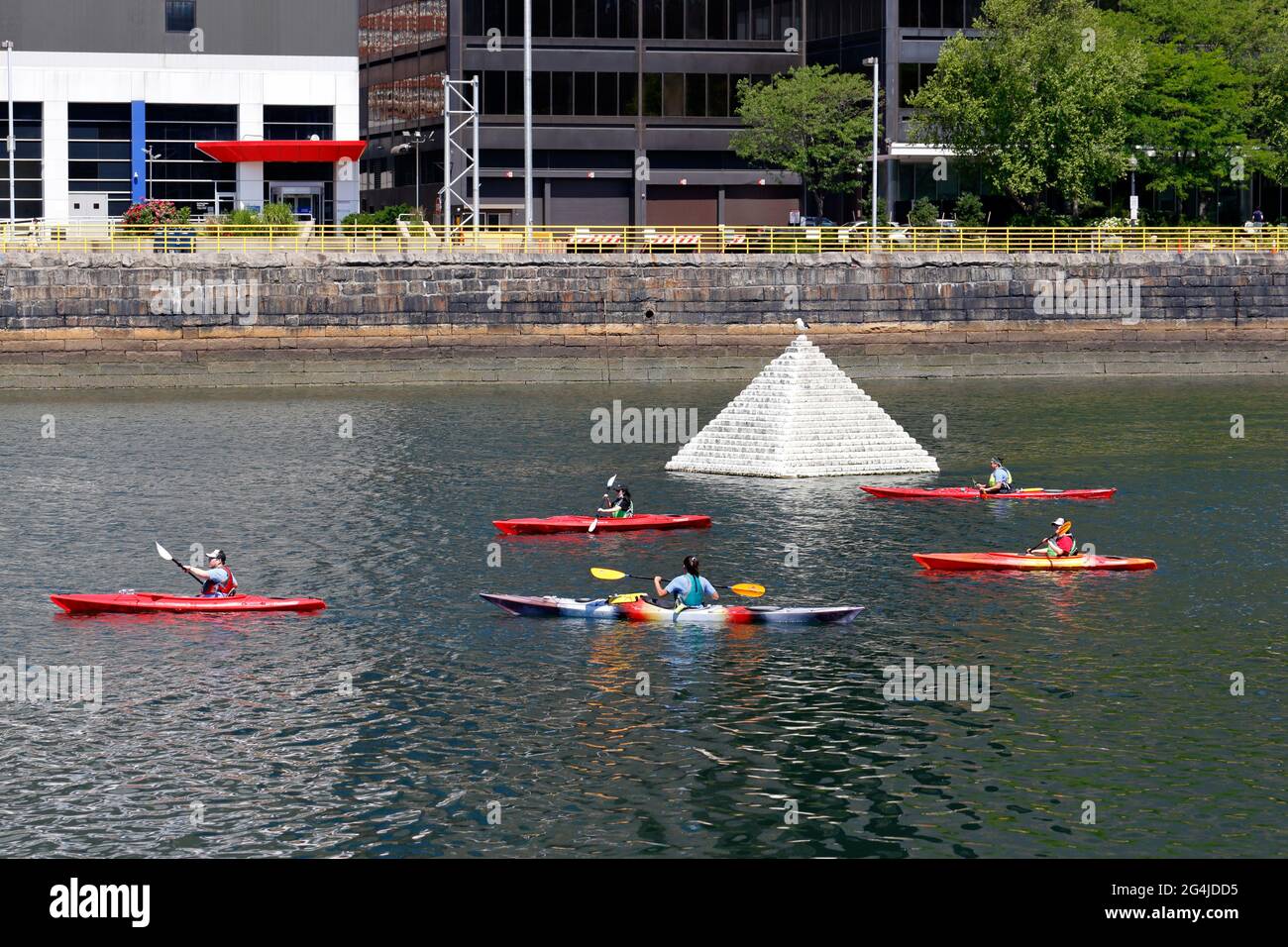 Kayakers in the Fort Point Channel next to the PYR 2014 floating pyramid in Boston, MA. Access to the water through Fort Point Pier, a public kayak la Stock Photo