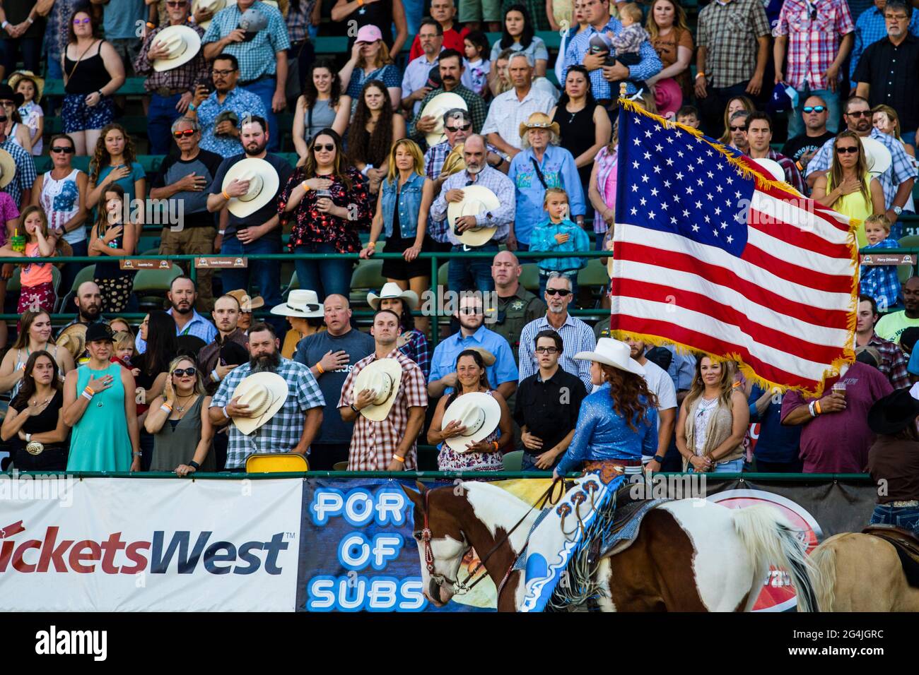 Reno Rodeo Flag Team present the flag from horseback for the national
