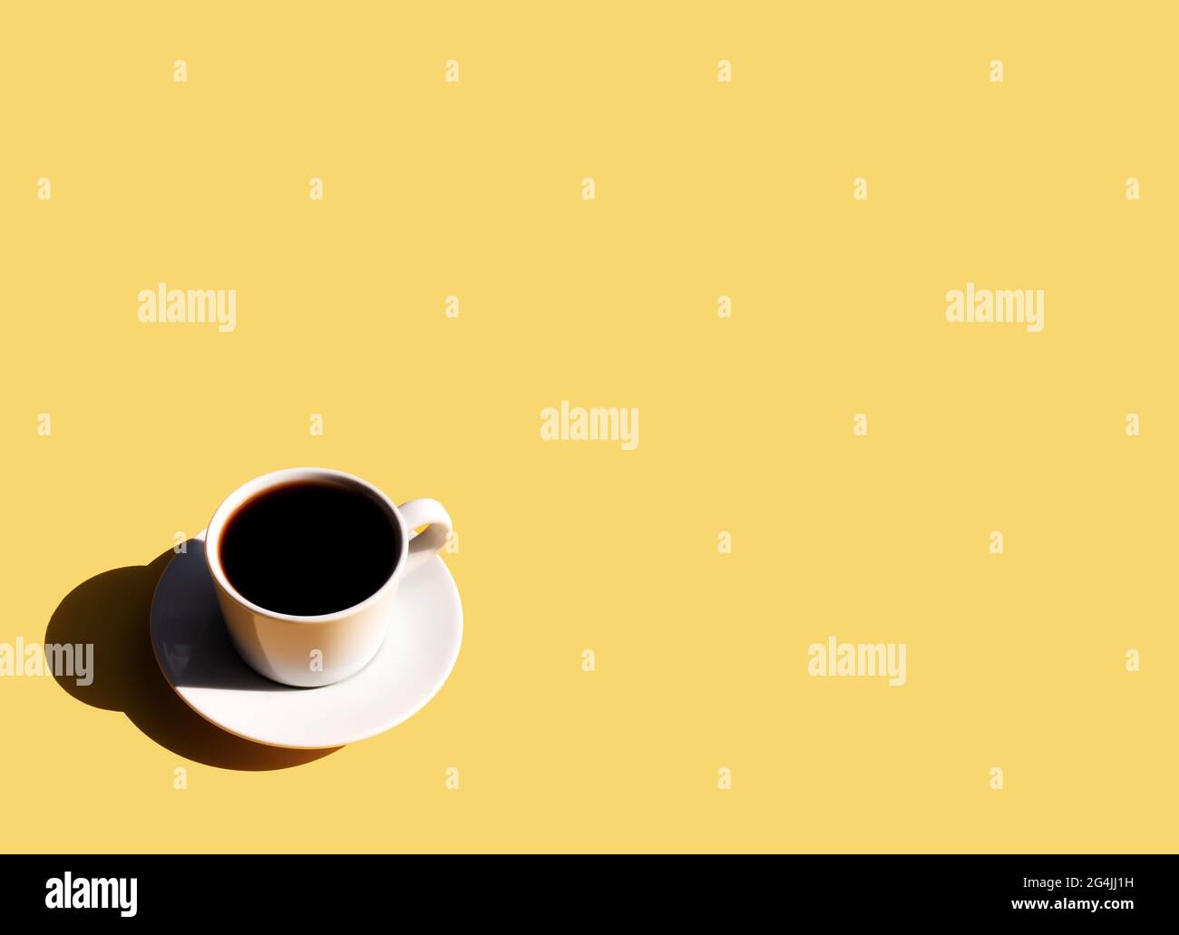 Single white cup and saucer plate of black espresso coffee from top view with shadow of sun on yellow beige terracotta background. High quality photo Stock Photo