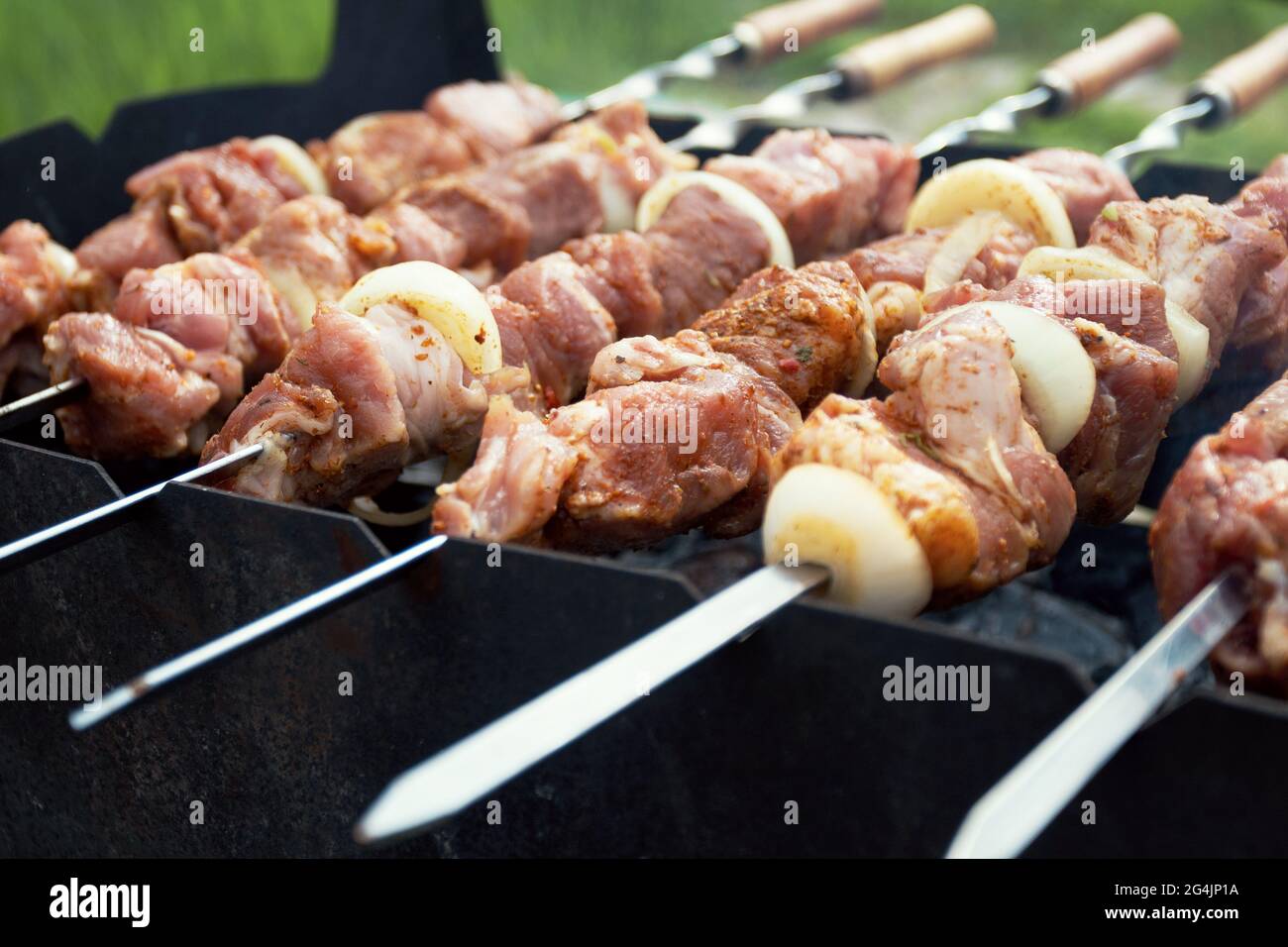 Grilling marinated shashlik on a grill. Shashlik is a form of Shish kebab  popular in Eastern, Central Europe and other places. Shashlyk meaning skewer  Stock Photo - Alamy