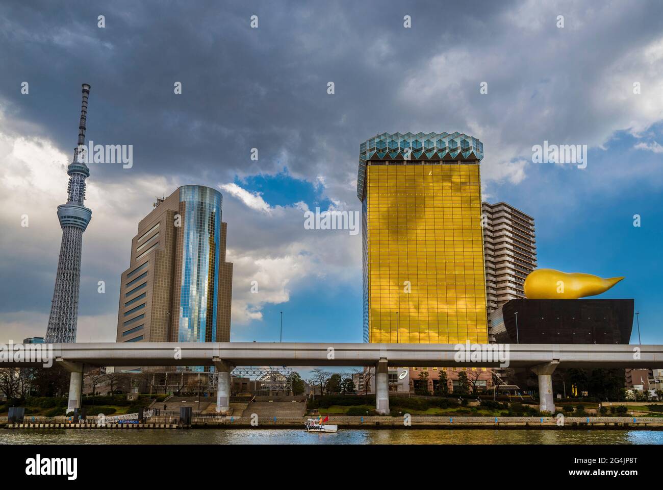 View of Sumida District with the iconic Asahi Beer Hall buildings, Skytree Tower and stormy clouds Stock Photo