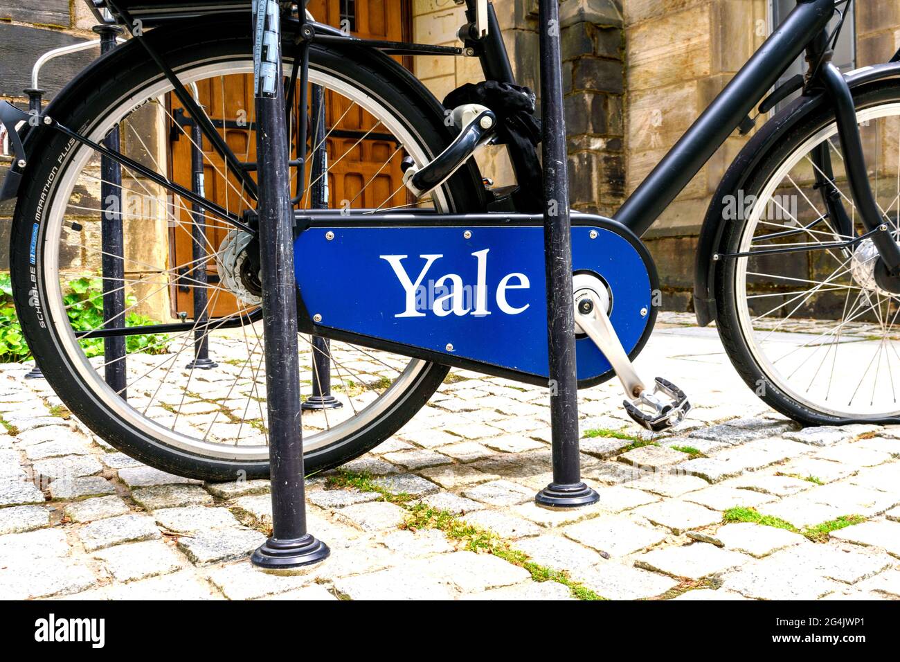 Yale sign on bicycle chain guard parked on cobblestone at historic building of Yale University. - New Haven, Connecticut, USA - 2021 Stock Photo