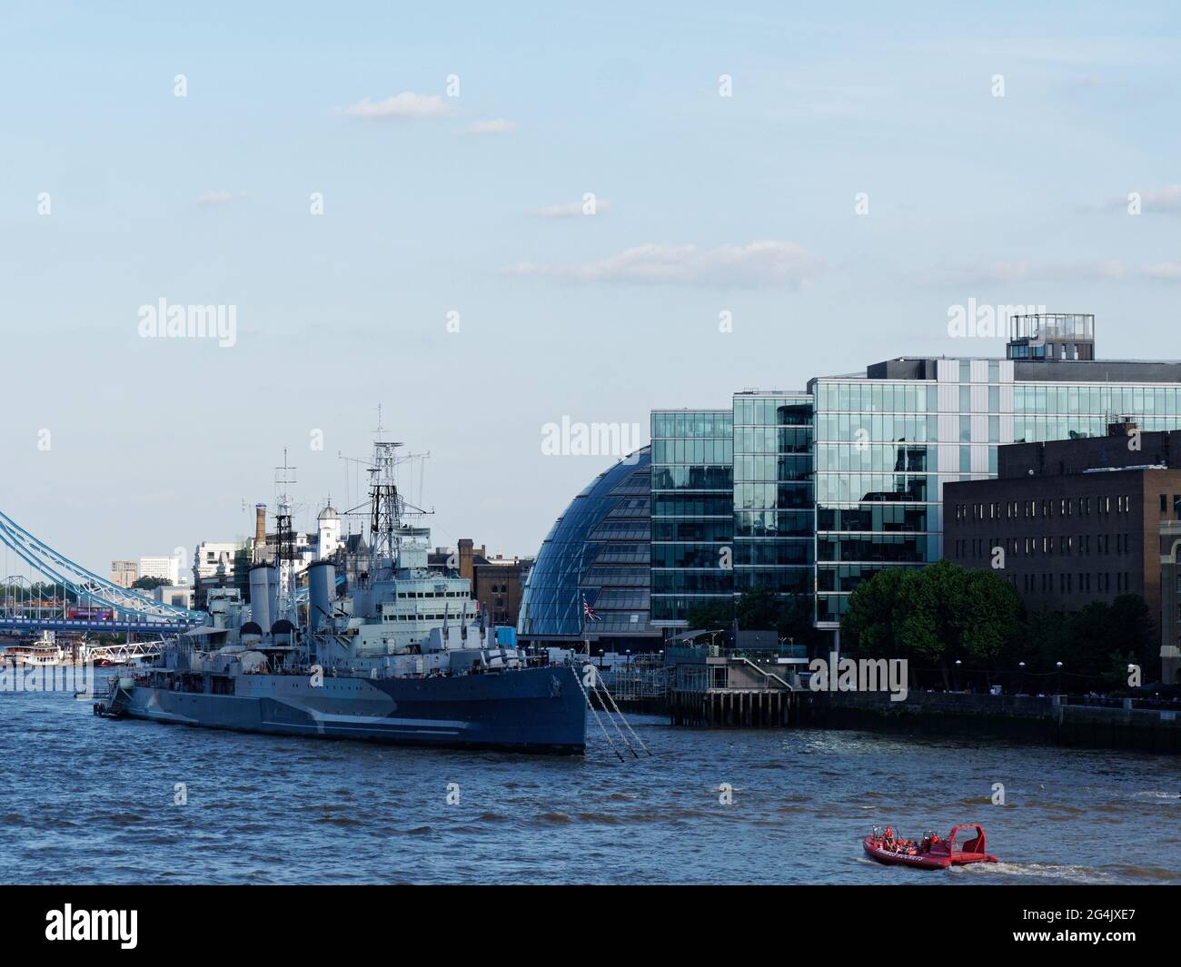 London, Greater London, England - June 12 2021: Modern building beside City Hall in Southwark with HMS Belfast on the River Thames. Stock Photo