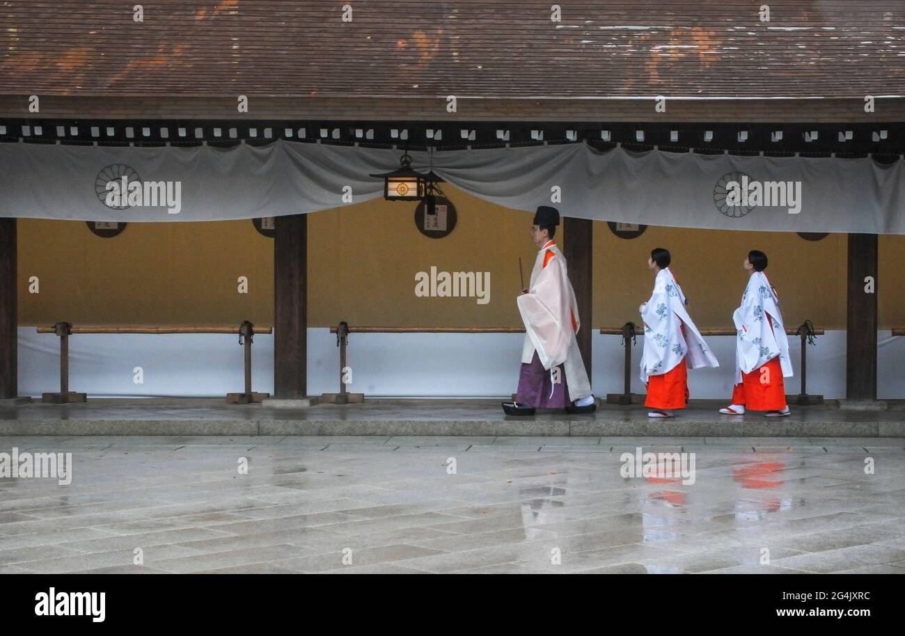3 people dressed in traditional japanese clothes in Meiji Jingu Shrine in Tokyo, Japan Stock Photo
