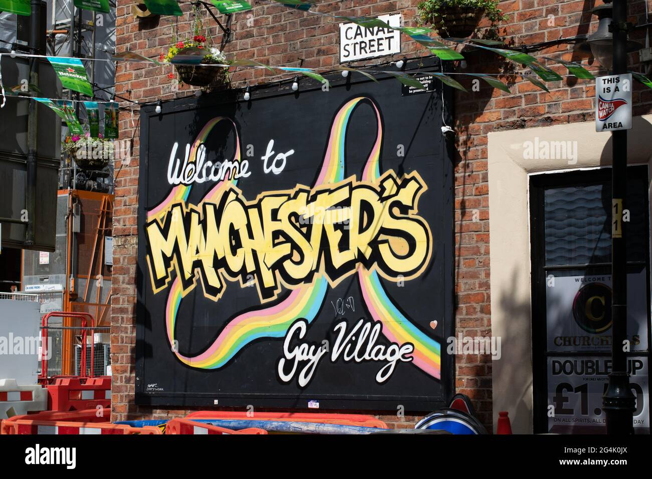 Canal Street, Manchester. Sign text Welcome to Manchester's Gay Village on the side of Churchills bar. Stock Photo