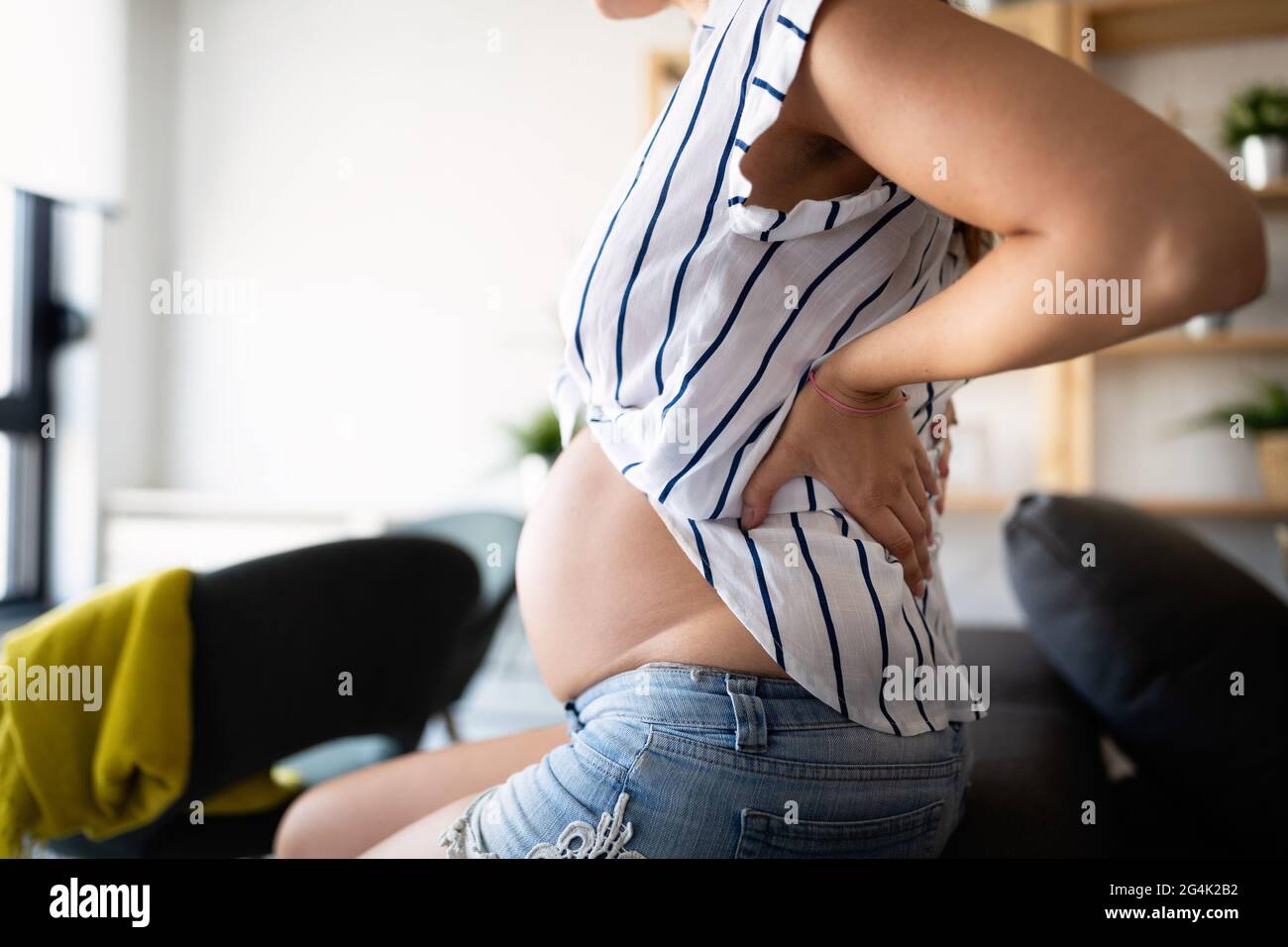 Pregnant woman suffering with nausea, cramps, pain Stock Photo