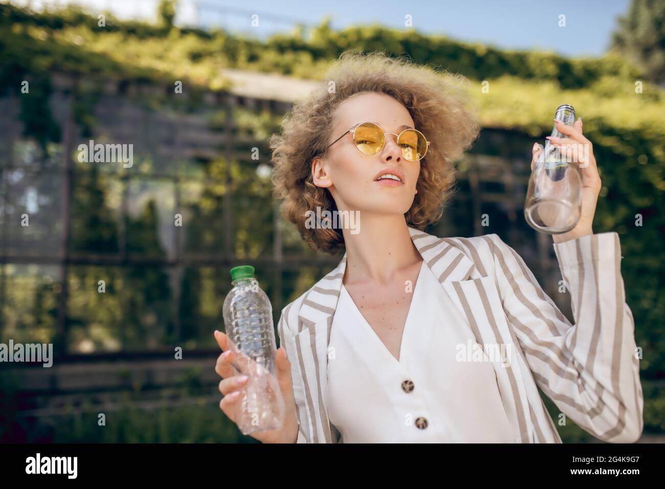 Fair-haired woman holding plastic bottles in hands Stock Photo
