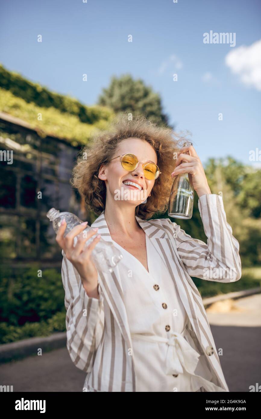 Fair-haired woman holding plastic bottles in hands Stock Photo