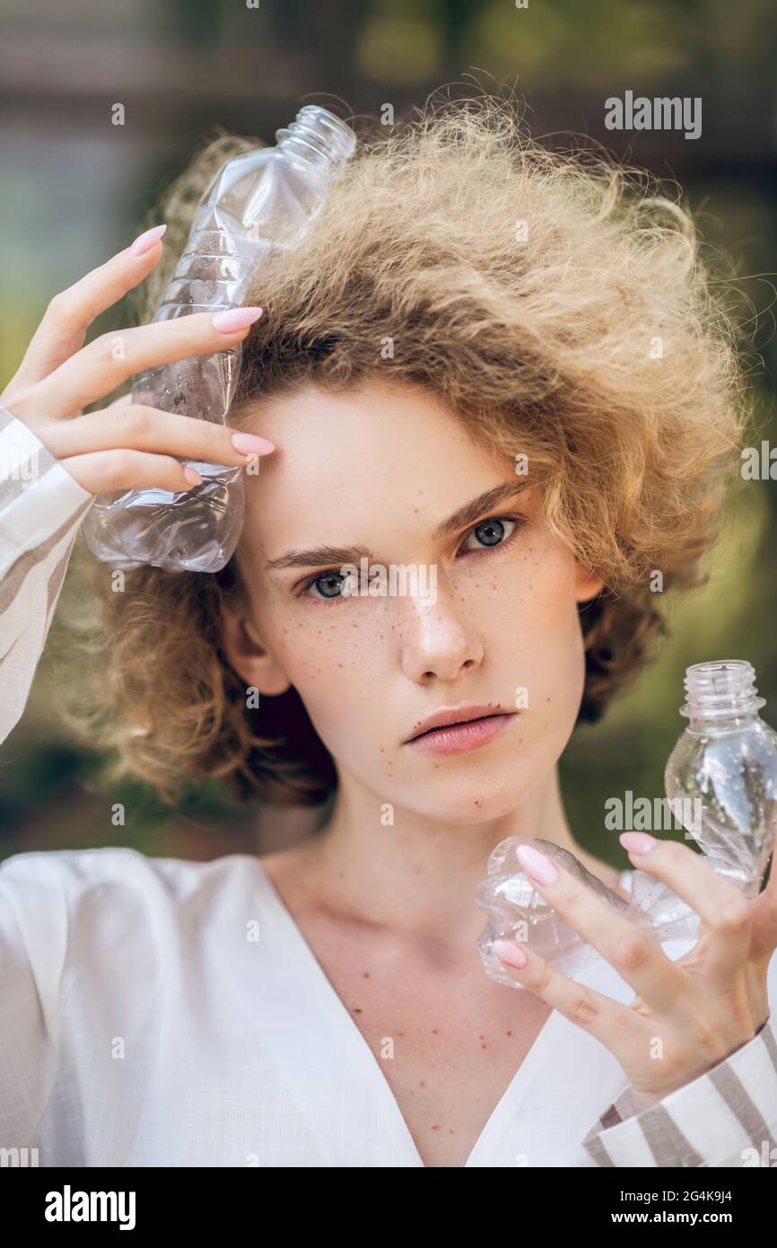 Fair-haired woman holding plastic bottles in hands Stock Photo