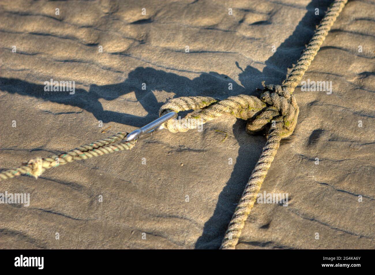 Strong mooring knot with carabiner and shadow on a beautiful sandy beach in Brittany, France Stock Photo