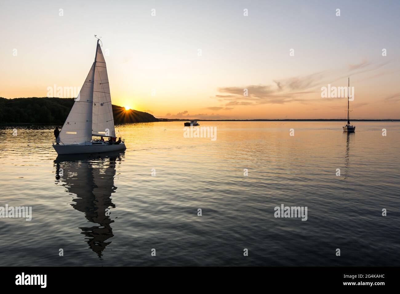Sailing boats drifting back into the harbour during scenic sunset at the Baltic Sea Stock Photo