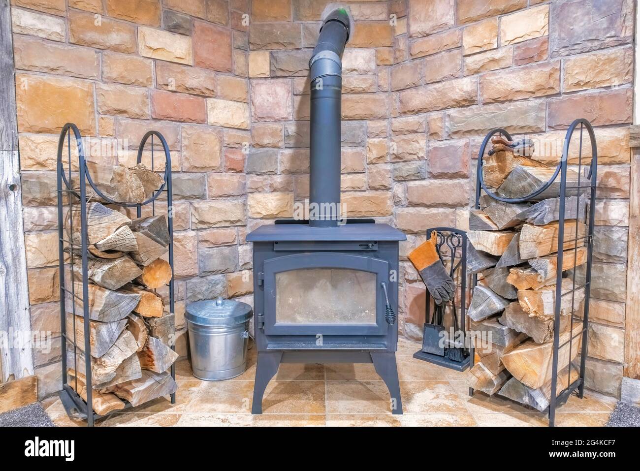 Vintage fireplace with chopped wood and brick walls Stock Photo