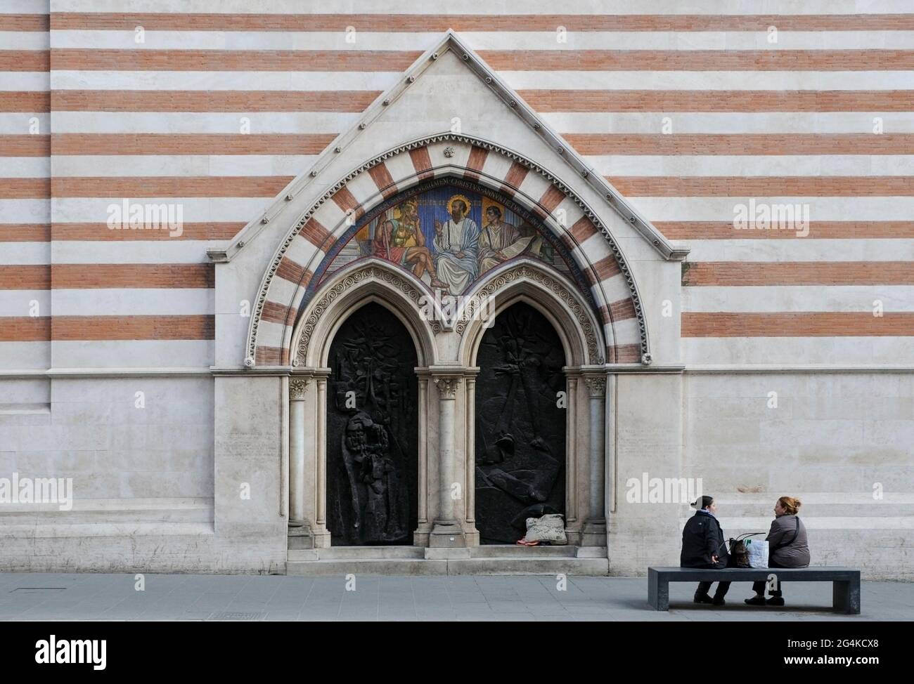 Two women sitting in front of a catholic church in Rome, Italy Stock Photo