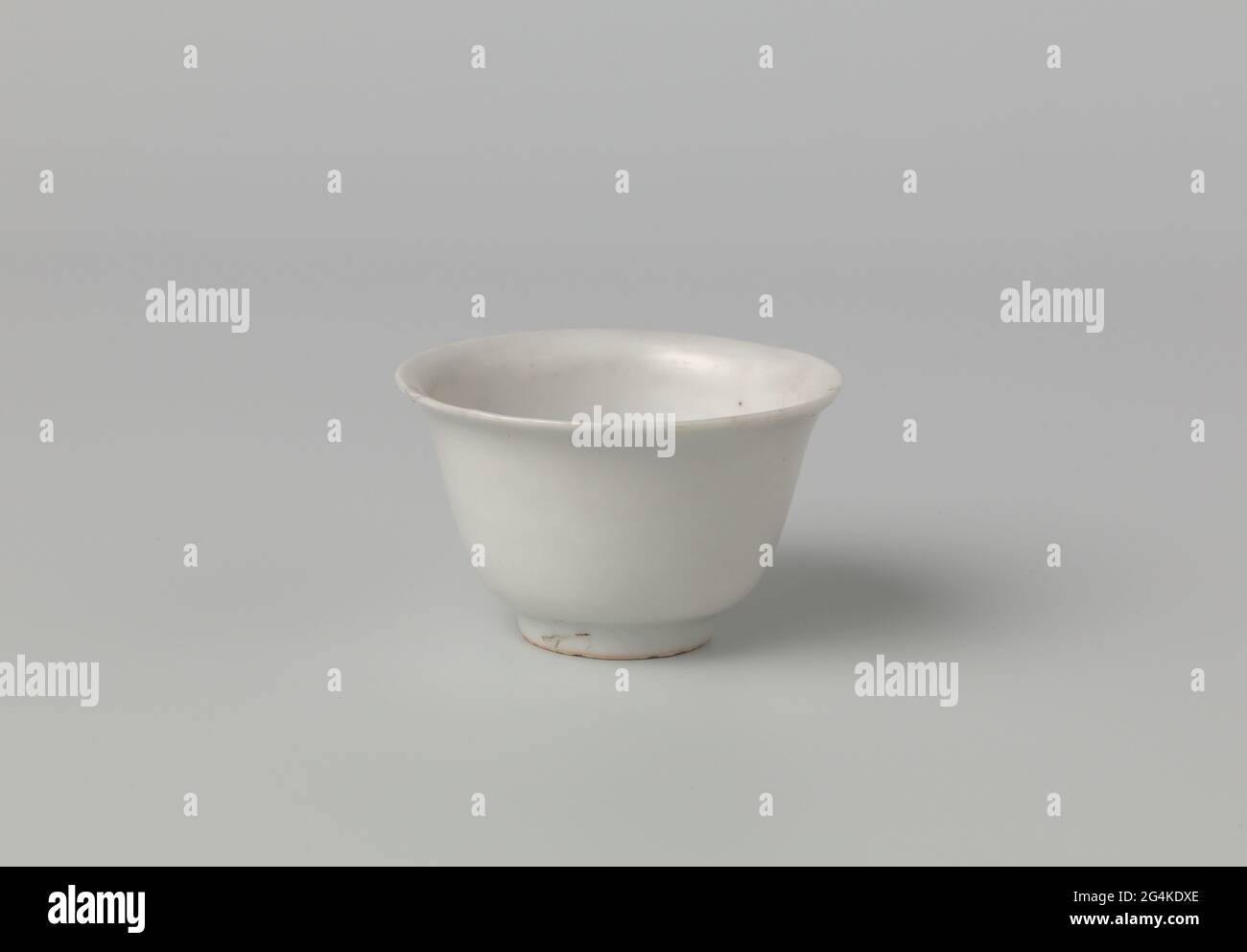Bell-shaped bowl with a white glaze. Bell-shaped bowl of porcelain, covered with a white glaze. Marked on the underside with an unidentified seal brand. A chip in the edge. White porcelain. Stock Photo