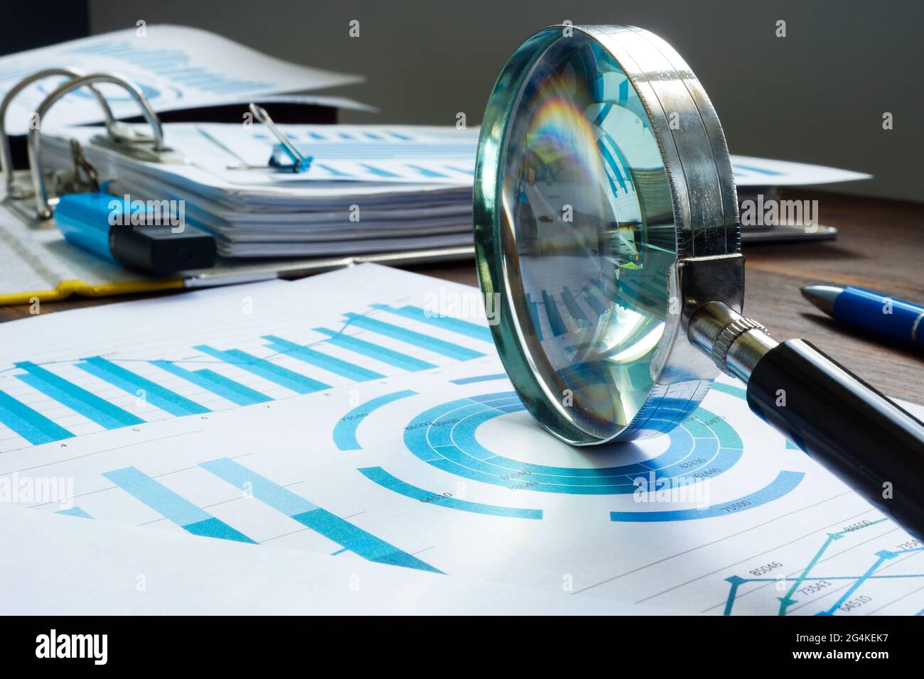 Magnifying glass as symbol of audit and papers. Stock Photo