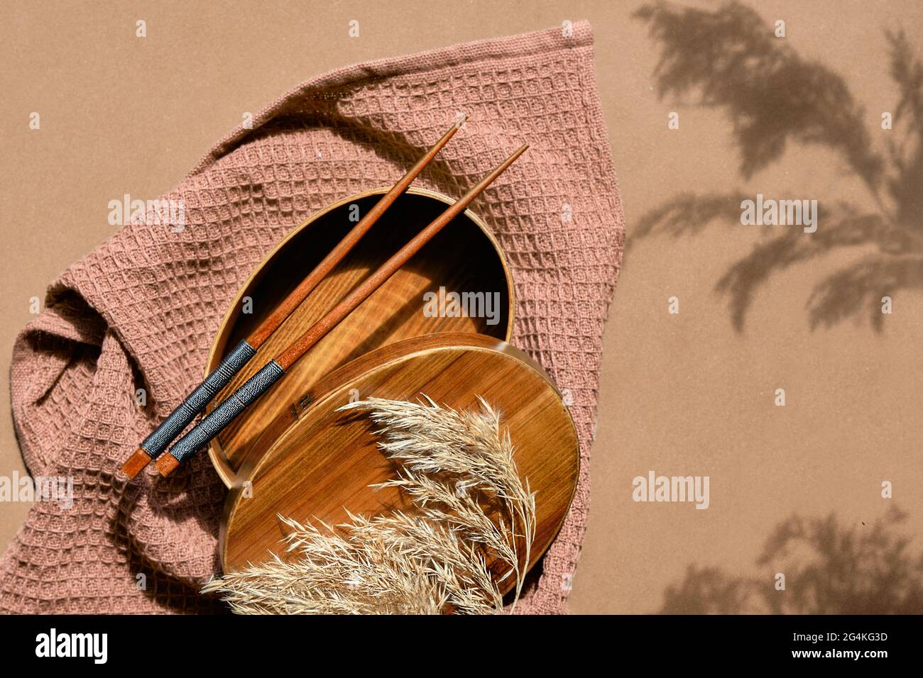 Text Packed lunch. Zero waste packed lunch box set on brown paper background. Lunch box, bamboo fork and spoon wrapped in furoshiki cloth. Trendy Stock Photo