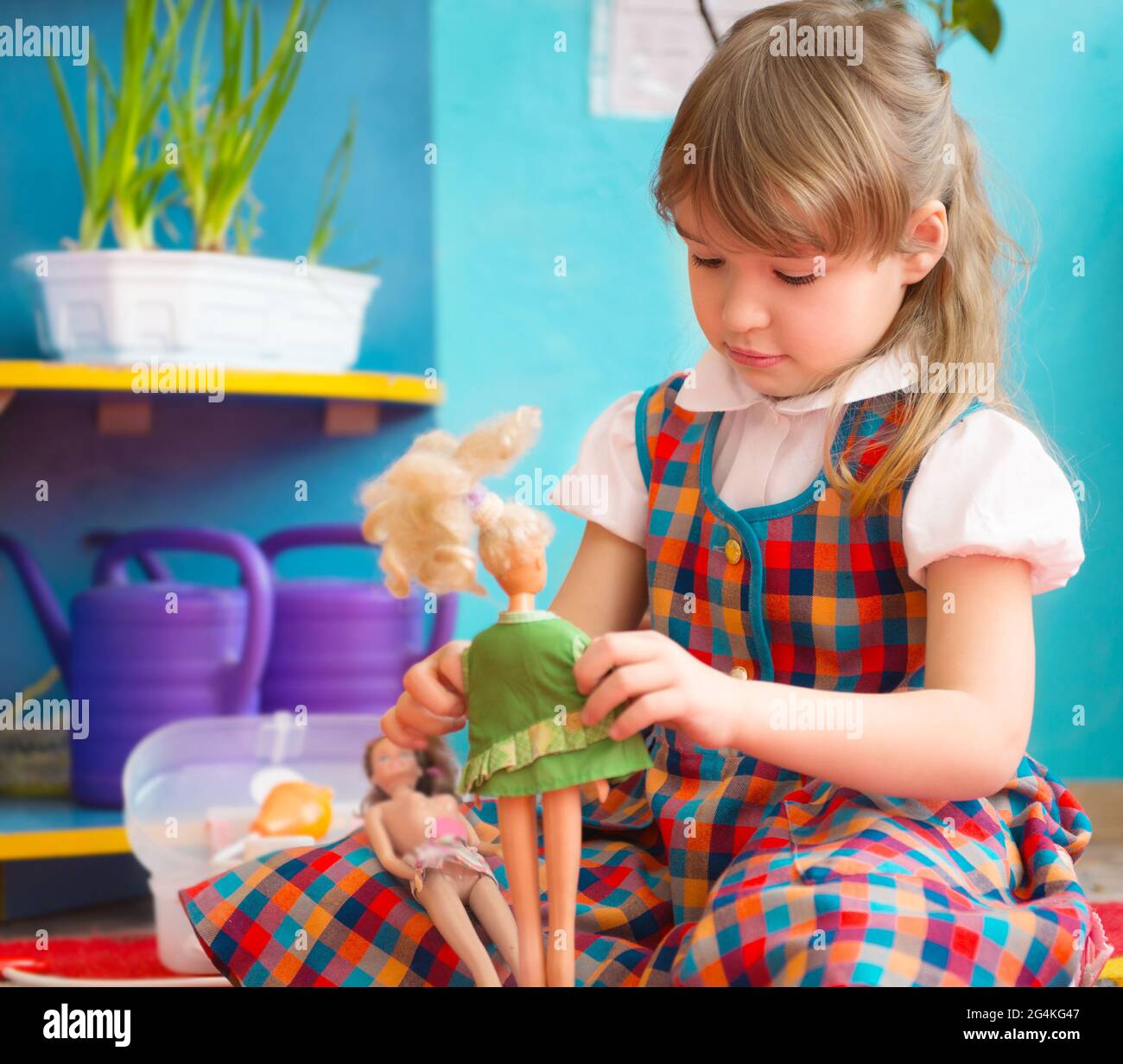 Cute little girl playing with toy doll at kindergarten Stock Photo - Alamy