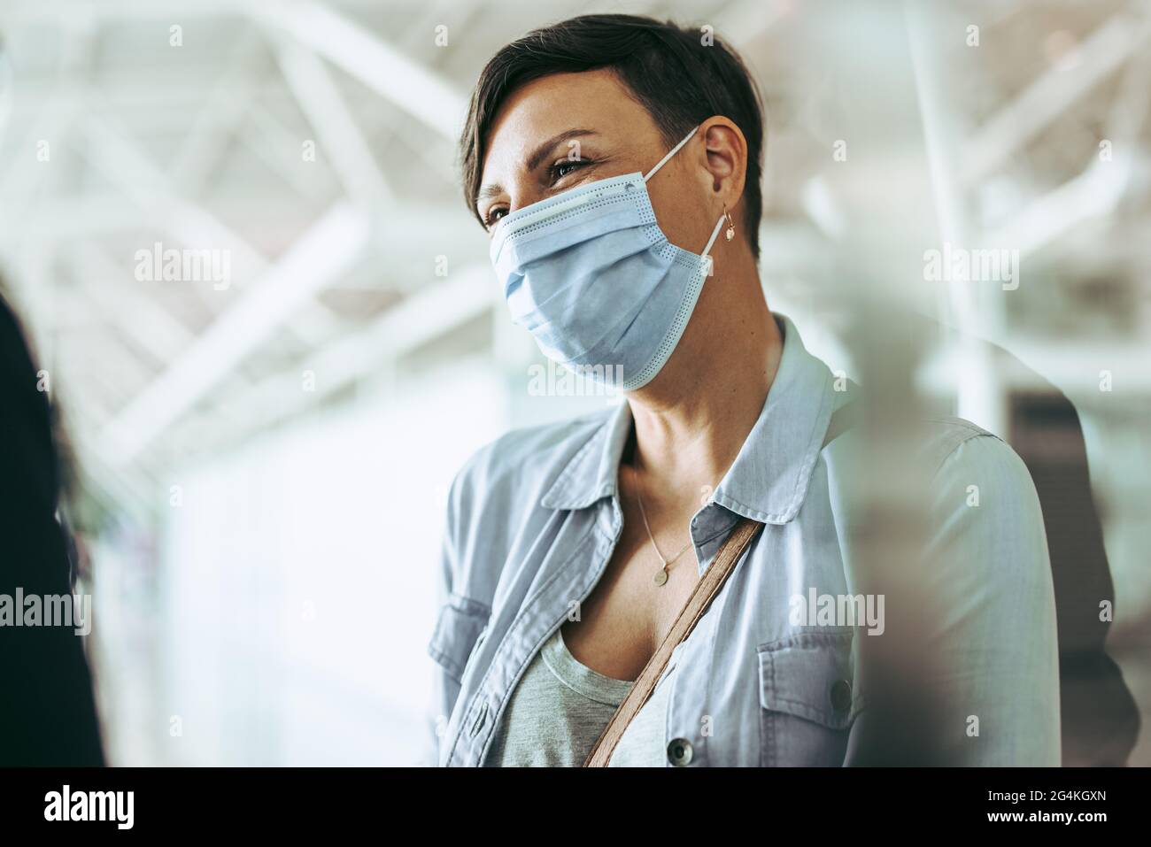 Woman traveler wearing face mask at airport. Female passenger during