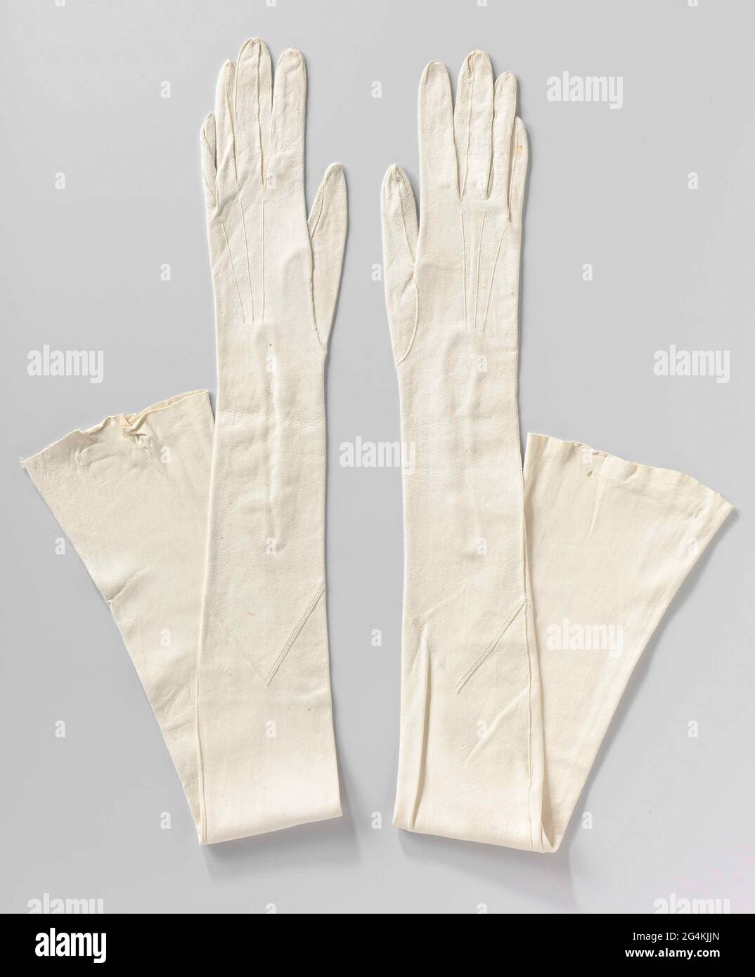 Left gloves from white clothes leather, with clasp of four pearly nuts.  Clear fitting model, up to the entire upper arm. Under the elbow a pointed  decorative stitching. Address: Gant Lavable /