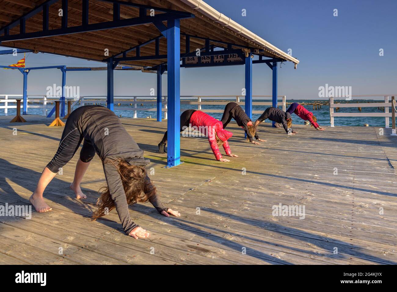 Women doing yoga in a mussel farm in the Alfacs bay in the Ebro Delta (Tarragona, Catalonia, Spain) ESP: Participantes en actividad de yoga (España) Stock Photo
