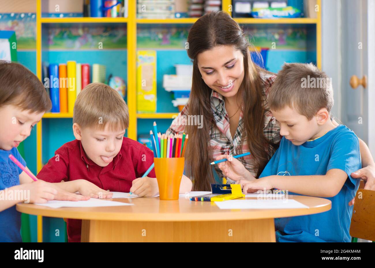 Cute little children drawing with teacher at preschool class Stock ...
