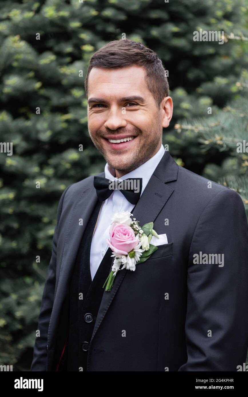 Groom in suit smiling at camera in park Stock Photo - Alamy