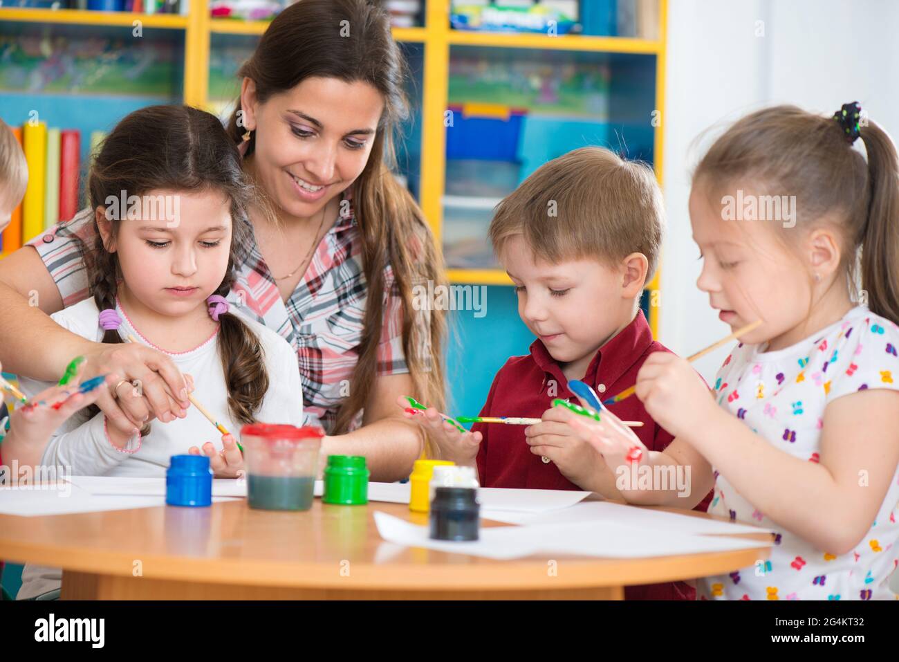 Cute little children drawing with teacher at preschool class Stock ...