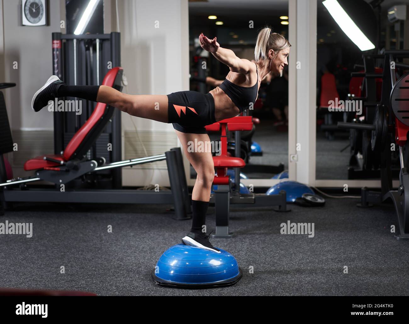Athletic woman doing legs workout with stability ball in the gym Stock ...